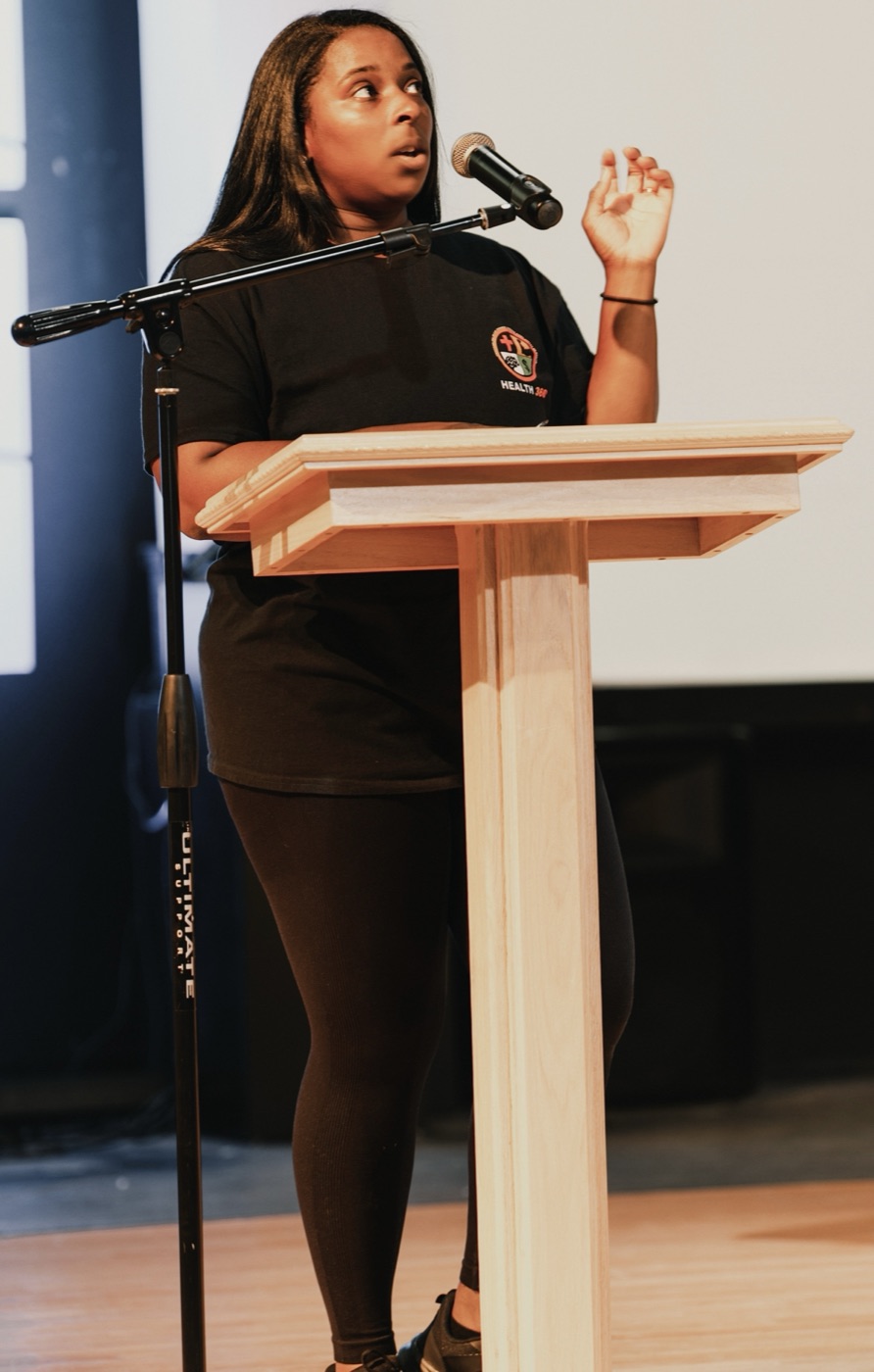 Presenter demonstrating a stretch during a corporate wellness event